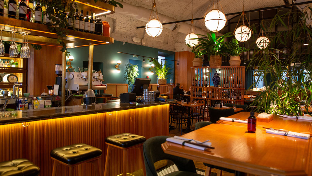 Artisan ponçant un comptoir en bois dans atelier de rénovation professionnel