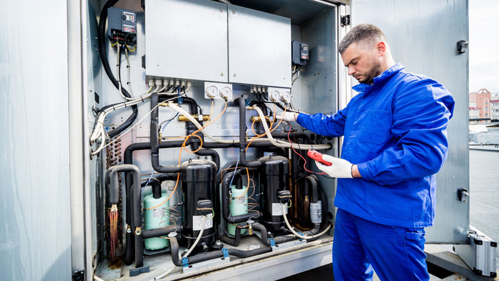 Technicien inspectant le groupe froid d'un comptoir réfrigéré professionnel